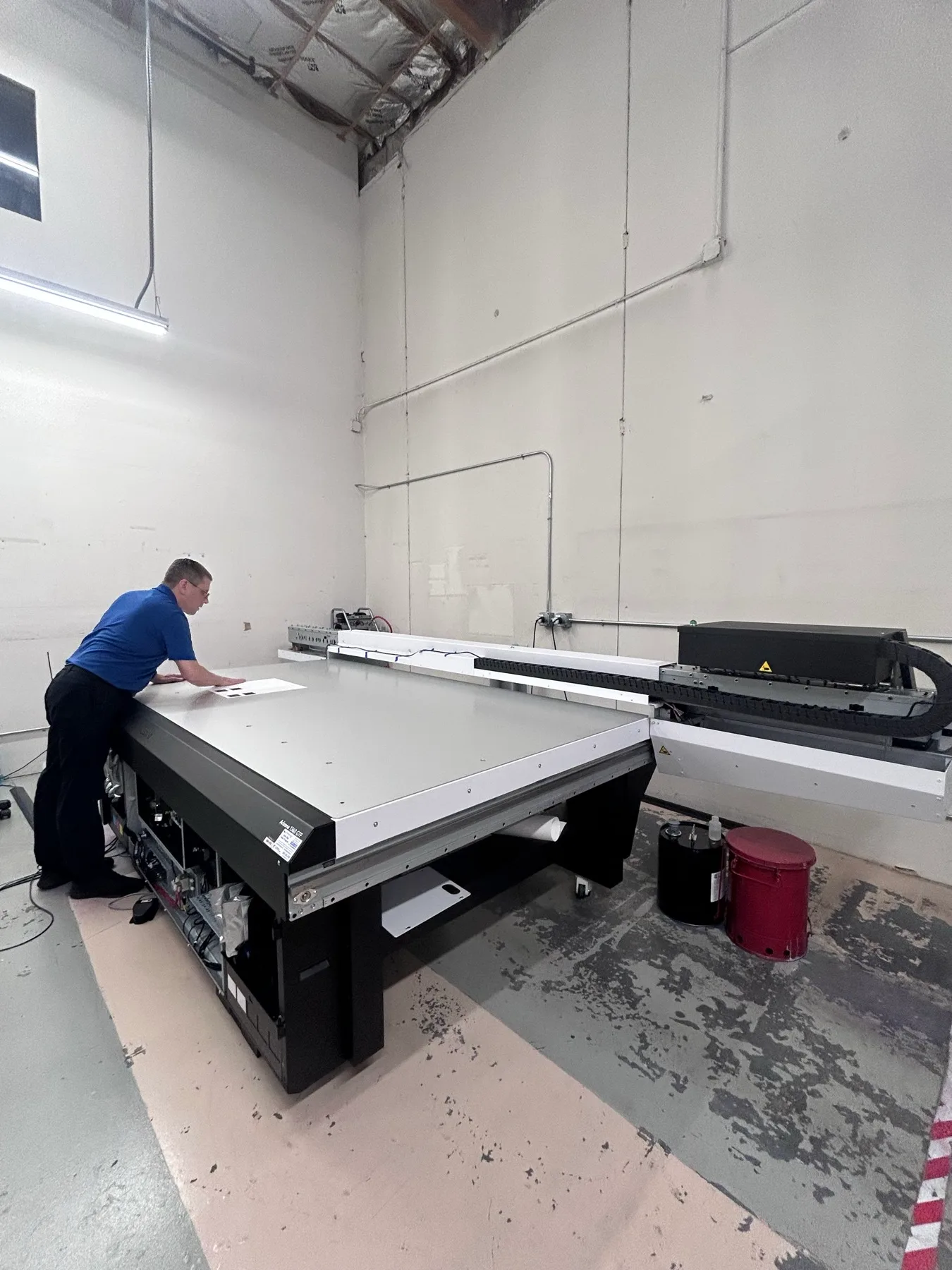 A technician positioning a small sample on the Arizona printer’s flat table during setup